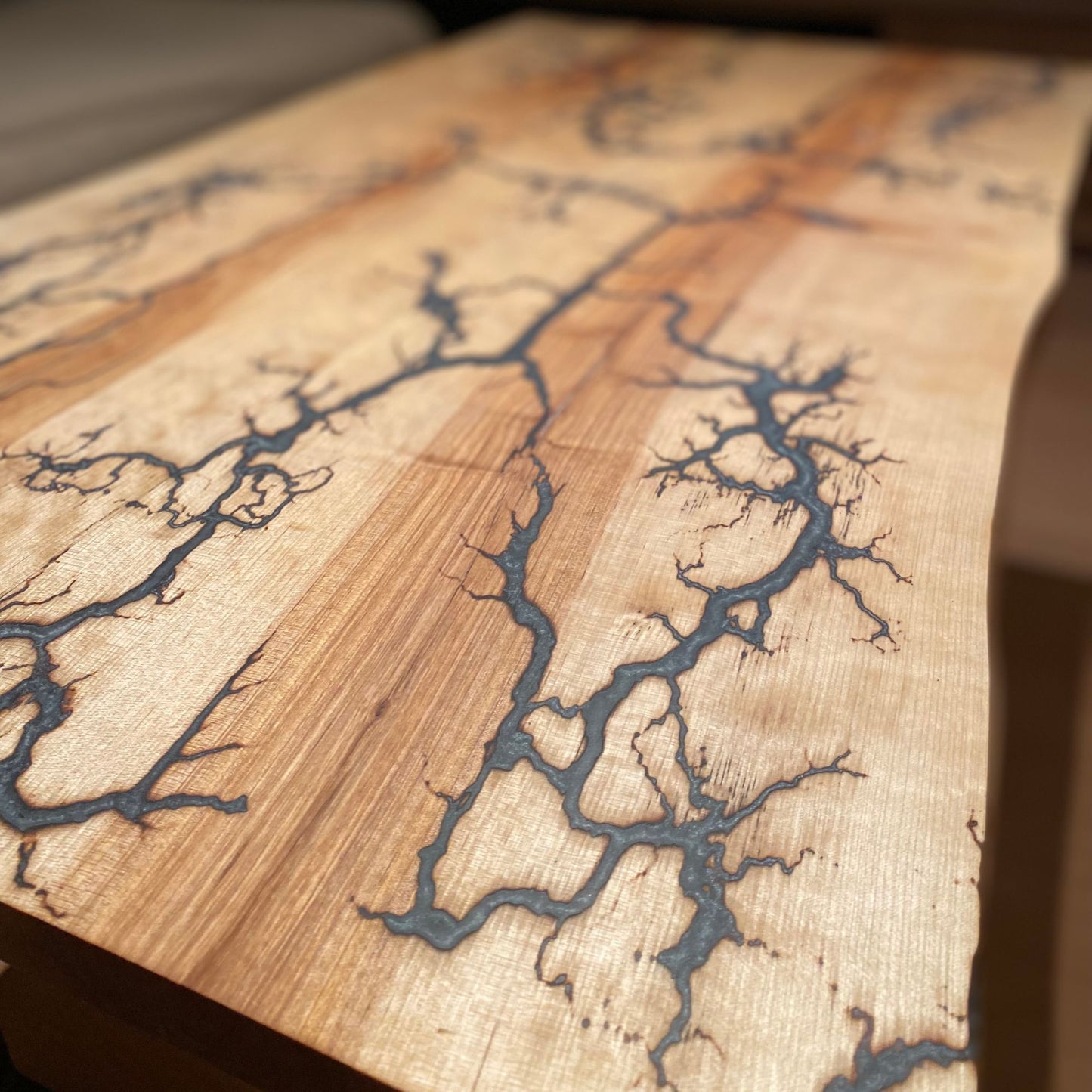 Ein Kunstwerk und Möbelstück in einem: Couchtisch mit Lichtenberg-Figuren und grau-weißem und silbernem Epoxidharz
